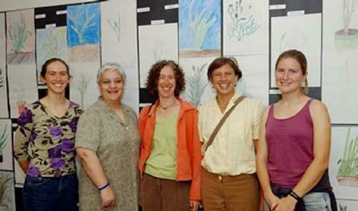 Photo of teacher Sarah Fonte, Principal Denise Beck, Artist Ruth Santer, UCD professor Pam Ronald, and UCD graduate student Becky Bart standing in front of student artwork.